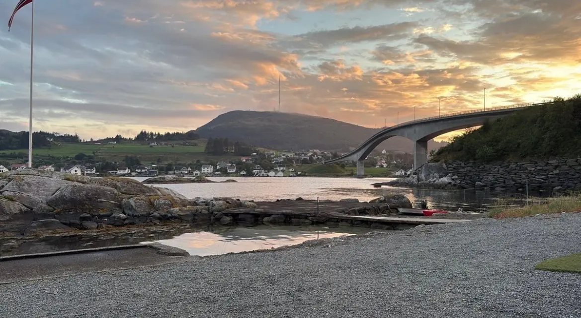 Badeplassen nedenfor campingplassen, med Boknbrua bak i solnedgang