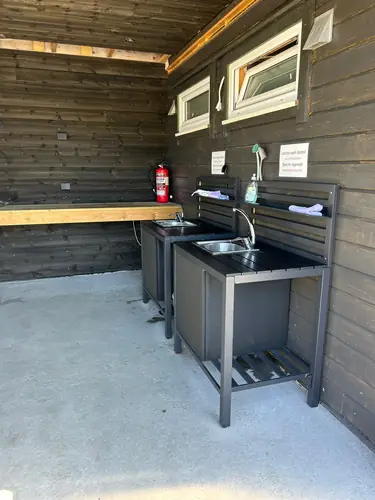 Den overbygde oppvaskplassen med stålkummer og benk