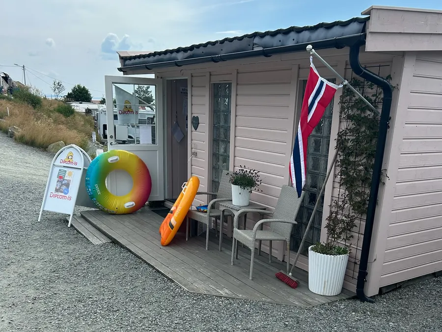 Kiosken Kråkebollå med norsk flagg og baderinger utenfor