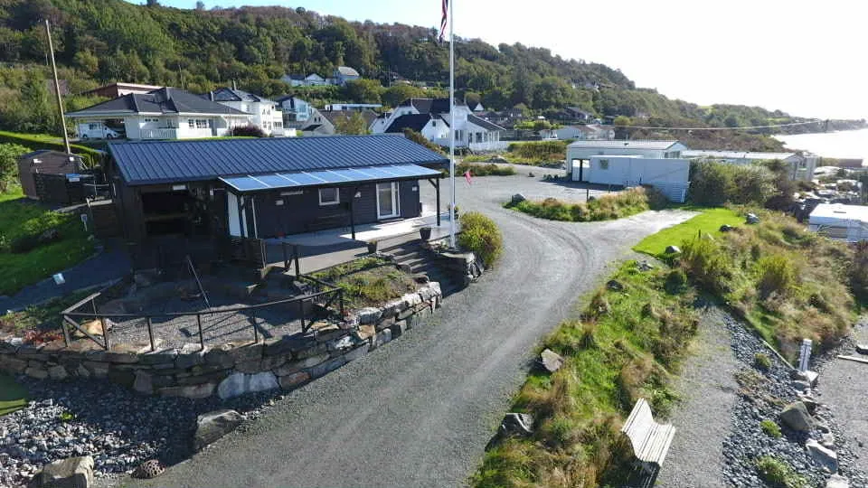 Austre Bokn Camping sett ovenfra, med servicebygget, grusveien og plassene langs stranda