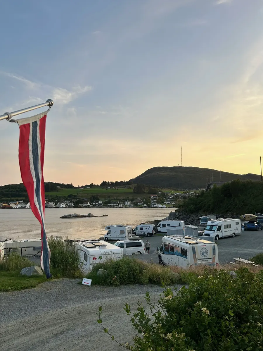Bobiler på oppstillingsplassene i kveldslys, med stranda og sundet bak